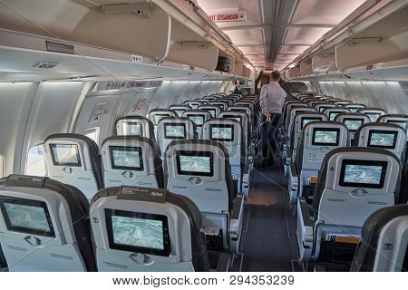COPENHAGEN, DENMARK - MAY 8, 2018: Icelandair flight from Reykjavik to Copenhagen. Boeing 757 cabin interior after people got off the plane upon arrival. Glow of the infotainment screens.
