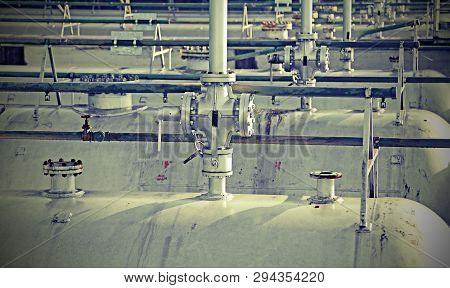 Many Tanks In The Storage Of Flammable Materials Of The Industrial Plant With Valves And Old Toned E