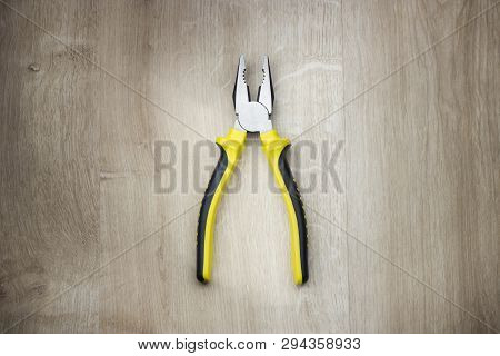 Combination Pliers In Workshop On Wooden Table. Isolated. Copy Space.