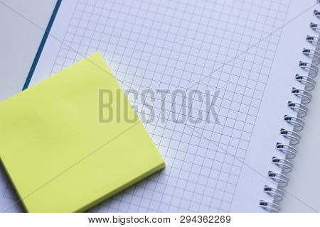 Blank Yellow Stick Note On A Spiral Notebook From Above. Removable Self-stick Notes.