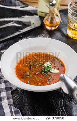 Red Beetroot Soup Borshch With Beef And Sour Cream On Black Table Side View