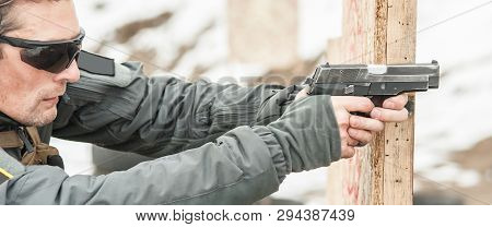 Shooter Holding Gun In Hand And Shooting. Close-up Detail View