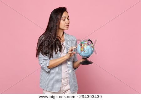 Curious Young Woman In Striped Jacket Holding Pointing Index Finger On Earth World Globe Isolated On