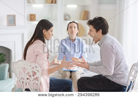 Couple Arguing During Therapy Session With Psychologist, Consulting Family Relationships Expert Or M