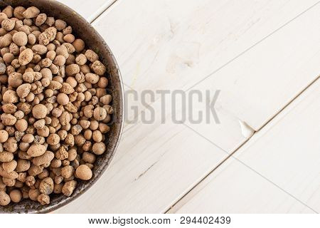 Lot Of Whole Brown Clay Pebbles (leca) On Grey Ceramic Plate Flatlay On White Wood