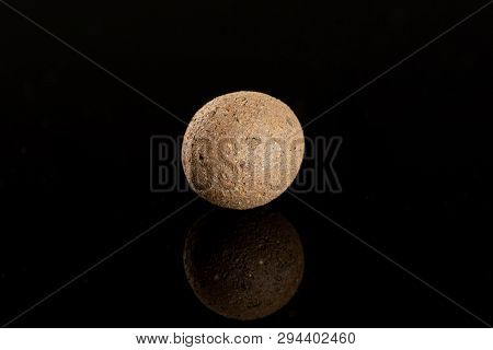 One Whole Brown Clay Pebbles (leca) Isolated On Black Glass
