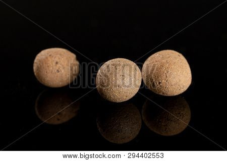 Group Of Three Whole Brown Clay Pebbles (leca) Isolated On Black Glass
