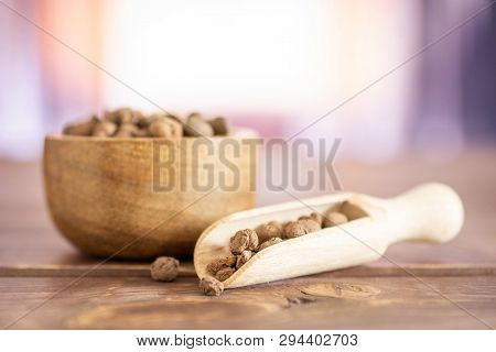 Lot Of Whole Brown Clay Pebbles (leca) With Wooden Bowl And Wooden Scoop With Silk Curtains Behind