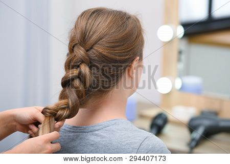 Professional Coiffeuse Braiding Client's Hair In Salon