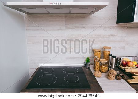 Luxury Kitchen With The Counter And Stoves Under Lights Near Chimney