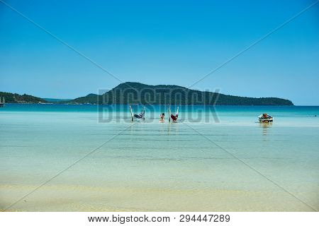 Girls In Hammock In The Beach At Nice Sunny Summer Day. Koh Rong Sanloem Island, Saracen Bay. Cambod