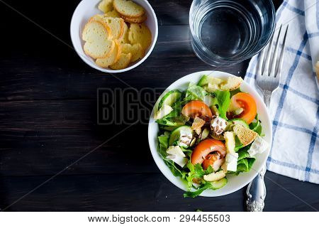 Fresh Light Green Salad With Cucumber, Lettuce, Avocado, Tomatoes, Cheeseand Sseeds And Glass Water 