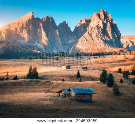 Small Wooden Houses In Beautiful Mountain Valley At Sunset. Autumn Landscape With Mountains, Buildin