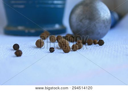 Black Peppercorns Ans Allspice In Ancient Metal Mortar With Pestle On Linen Background. Old Home Kit