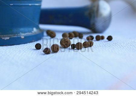 Black Peppercorns Ans Allspice In Ancient Metal Mortar With Pestle On Linen Background. Old Home Kit