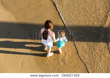 Two Children Playing In The Sand At The Beach Topdown Pov