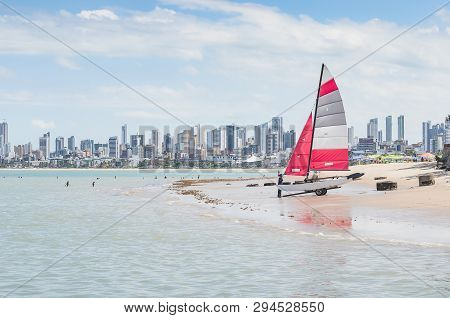 Carrying A Sailing Boat On A Beach. Praia Do Bessa Beach, Joao Pessoa Pb, Brazil. Beachfront Buildin