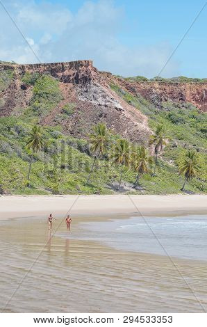 Conde - Pb, Brazil - February 22, 2019: Two People Walking On The Sand Of Praia De Coqueirinho Beach