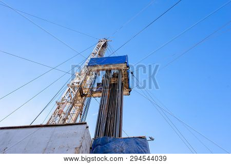 Oil And Gas Drilling Rig Onshore Dessert With Dramatic Cloudscape. Oil Drilling Rig Operation On The