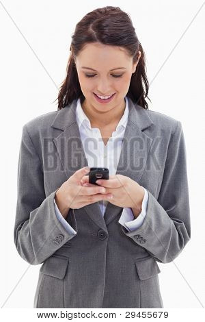 Close-up of a businesswoman smiling and watching her phone against white background