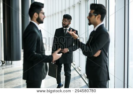 Young Asian Businessmen Have Informal Meeting In Office Hall In Front Of Walking Collegue