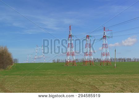 Supports Power Lines Are In The Field. Red And White. New Line