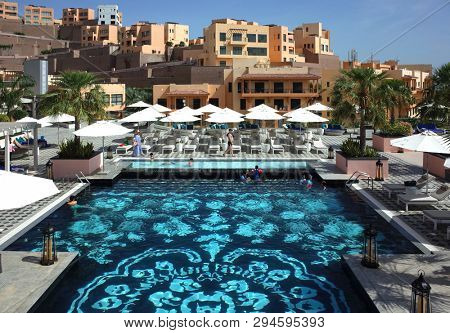 Dibba Al-Fujairah, Fujairah, UAE - April 6, 2019: Swimming pool of Fairmont Fujairah beach resort and Mina Al Fajer buildings