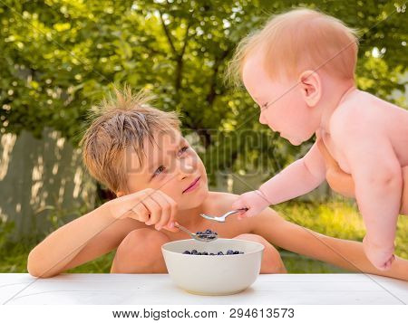 Sibings Eating Fresh Juicy Berries. Happy Childhood Concept. Healthy Food. Healthcare Of Children. T