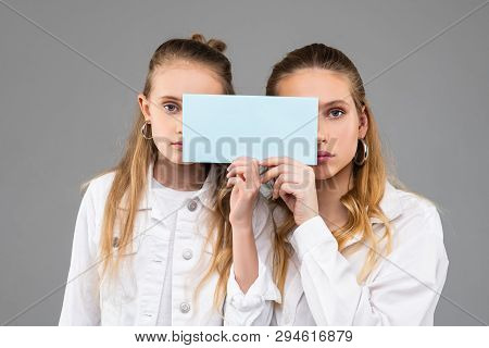 Appealing Good-looking Similar Girls In White Outfits Carrying Clear Nameplate