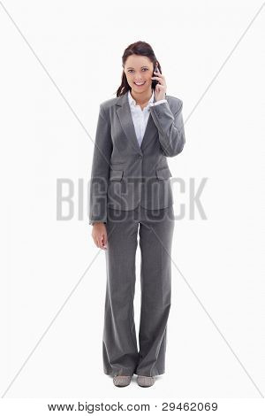 Smiling businesswoman using a phone against white background