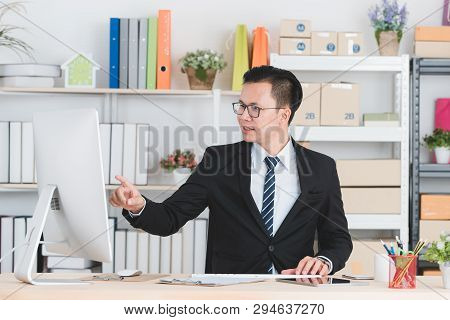 Portrait Of Young Handsome Asian Businessman Wearing Eyeglasses In Dark Suit, Working In Modern Star