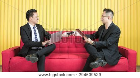 Young And Middle Aged Asian Businessmen Wearing Eyeglasses In Dark Suit, Both Busily Checking Data F
