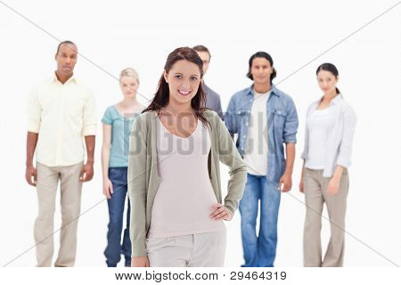 People behind a smiling woman with her hand on her hip in foreground