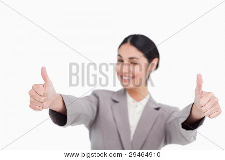 Thumbs up dato da sorridente giovane imprenditrice contro uno sfondo bianco