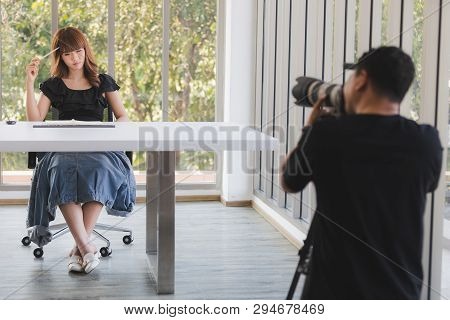 Photographer And Stylist Team Working On Studio Portrait Of Young Beautiful Asian Woman With Dark Br