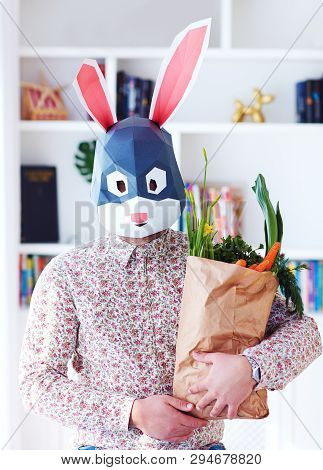 Young Adult Bunny Rabbit Holding A Paper Bag Full Of Fresh Greens And Carrots