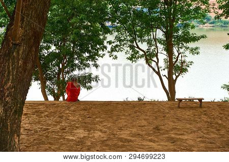 Monk Sits At River In Pakse Mekong River In Laos