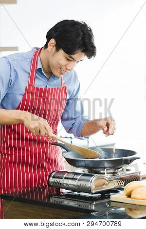 Close Up Shot Of Good Looking Asian Man Fried Hamburger In Pan On Stove, There Are Hamburger Ingredi
