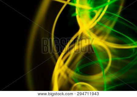Yellow And Green Neon Lines Abstraction. Neon Lights.   Isolated On Black Background. Modern Art.