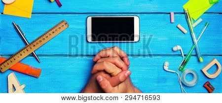 The Student Crossed His Hands In Front Of A Mobile Phone In The Workplace. A Place For Text. A Stude
