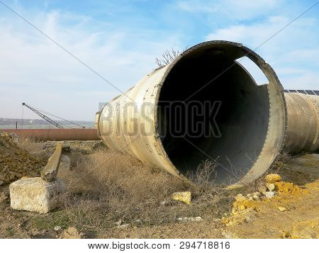 Old Rye Pipes Of Large Diameter Lie On The Ground. Pipeline. Large Iron Drainage Pipes Connect Two R