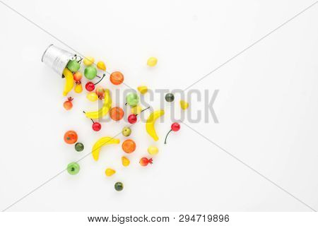 A Scattering Of Many Small Different Fruits On A White Background. Mini Copy Of A Metal Bucket. The 