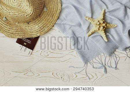 Womens Straw Hat, Red Passport And Plane Ticket, Blue Tippet And Starfish On A White Wooden Backgrou