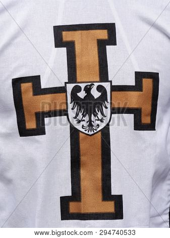 Closeup of white cape with Teutonic cross