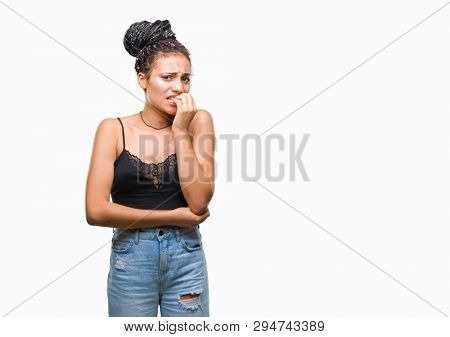 Young braided hair african american with pigmentation blemish birth mark over isolated background looking stressed and nervous with hands on mouth biting nails. Anxiety problem.