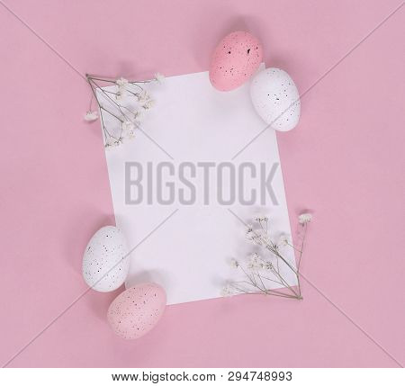Easter Eggs And White Blossoms Around Blank Note Paper, On A Pink Background. Flat Lay With Copy Spa