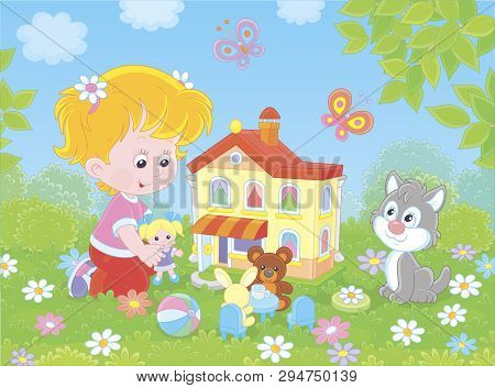 Cute Little Girl Playing With A Small Doll, A Bear, A Rabbit And A Toy House Among Flowers On A Sunn