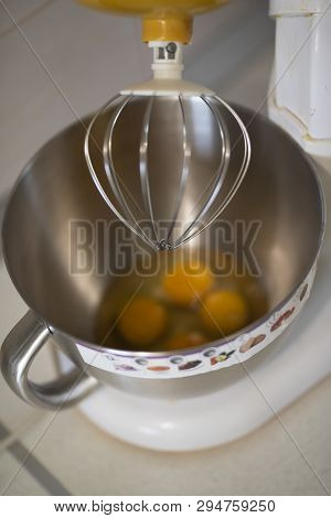 Kitchen Front With Planetary Mixer With Egg Whites And Yolks In A Metalic Bowl Waiting To Be Stirred