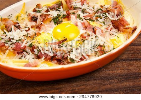 Breakfast. Scrambled Eggs With Bacon, Meat, Grated Parmesan Cheese, In Ceramic Ware, On A Wooden Sta
