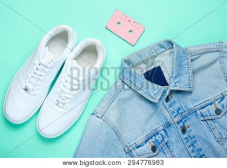 Retro Style Denim Stylish Jacket, Audio Cassette And White Hipster Sneakers On A Mint-colored Paper 